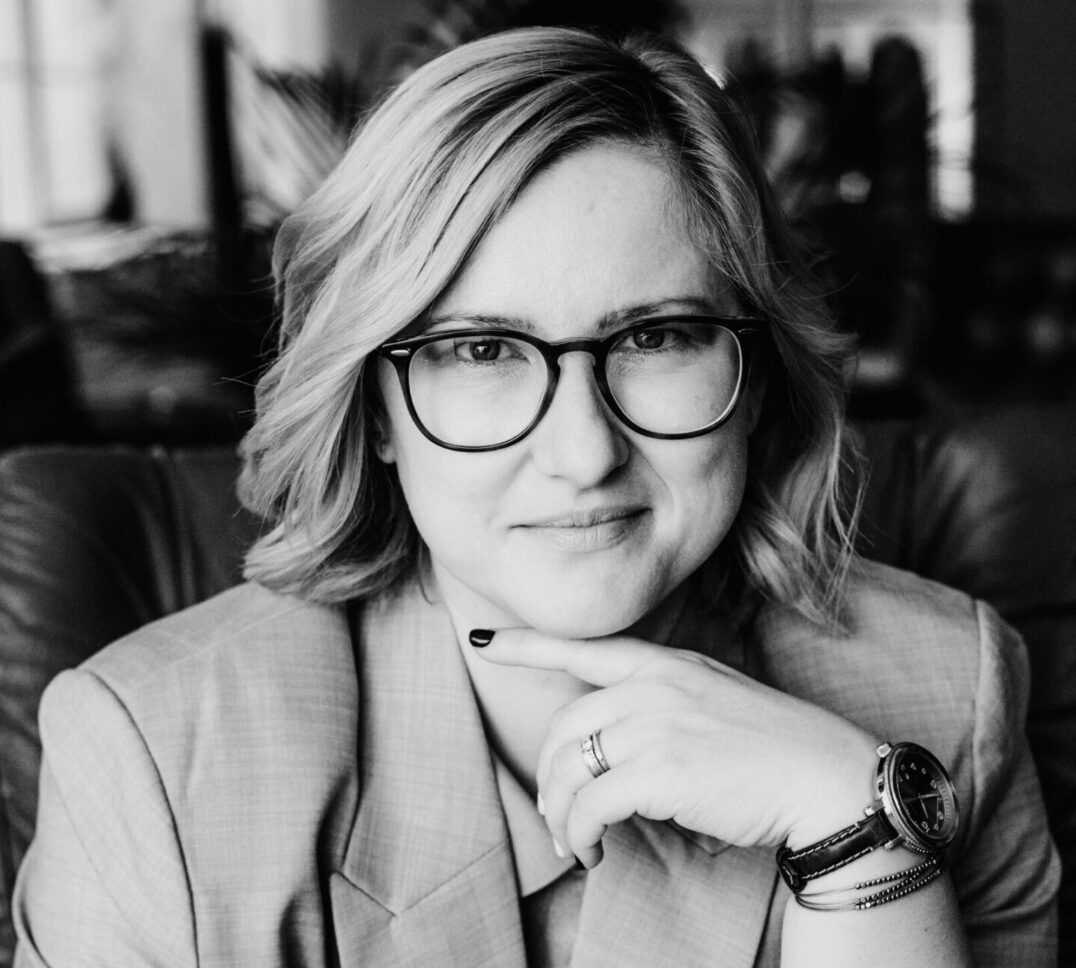 Oana Leonte featured in business media interview portrait, wearing glasses and suit